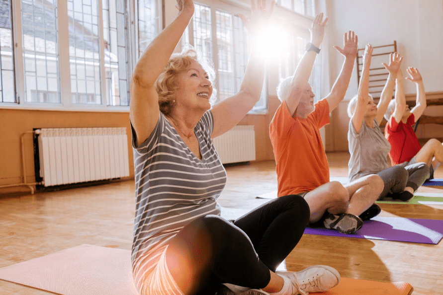 Seniors participating in a group stretching exercise at a retirement community.