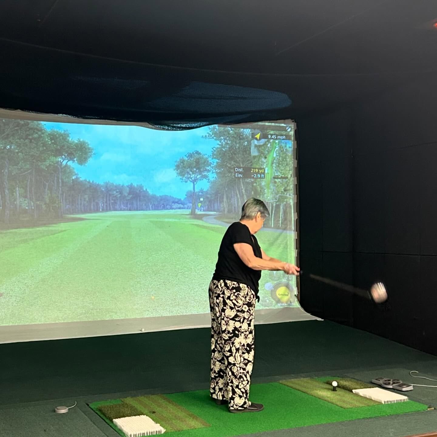 An elderly woman is playing golf.