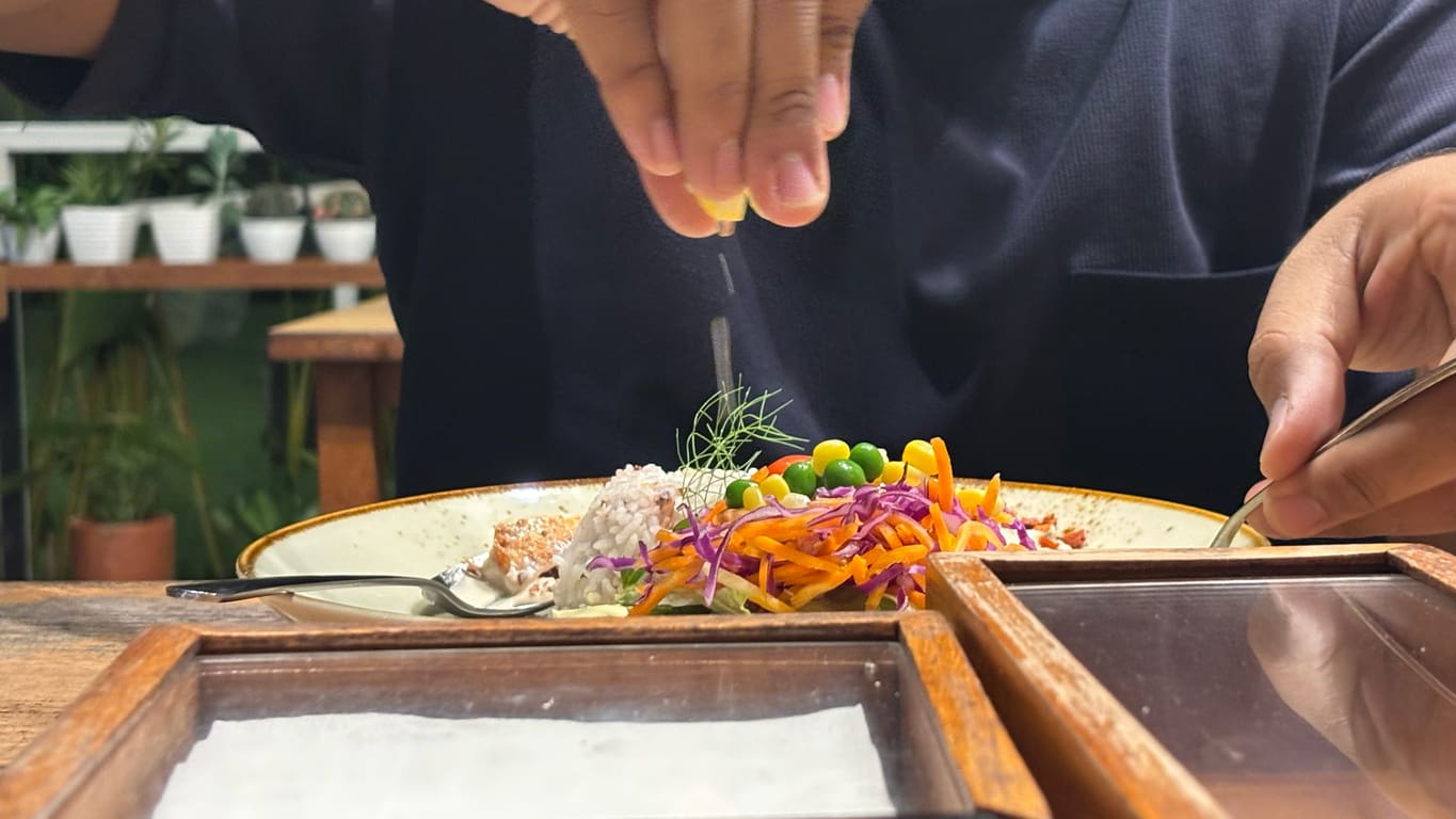 Chef finishing a fresh, healthy plated meal in a retirement community dining setting.