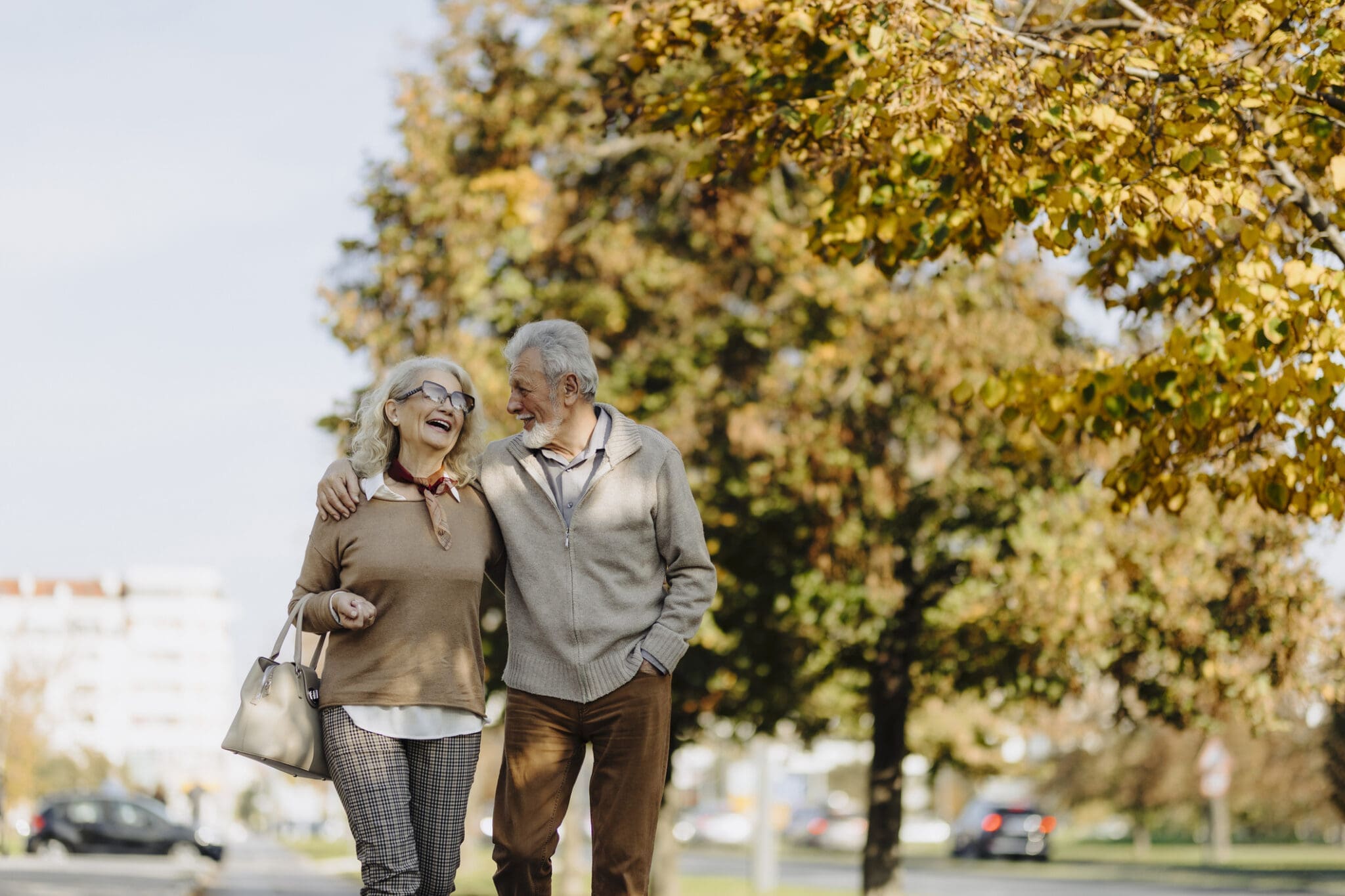 A happy senior couple enjoying a brisk walk for light fitness near the Meadowlands retirement community in Ancaster